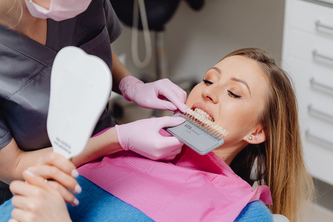 Dentist matching tooth shade with a patient using a shade guide
